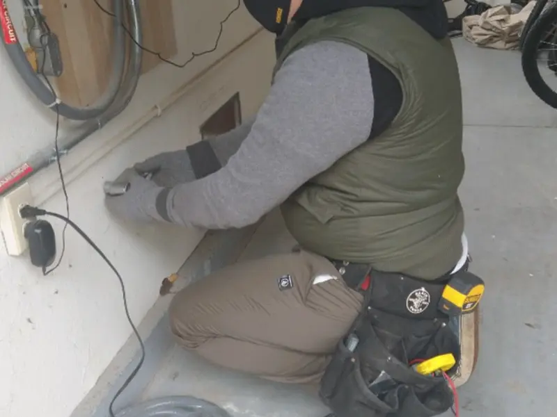 Electrician performing outlet wiring in a Minot AFB garage