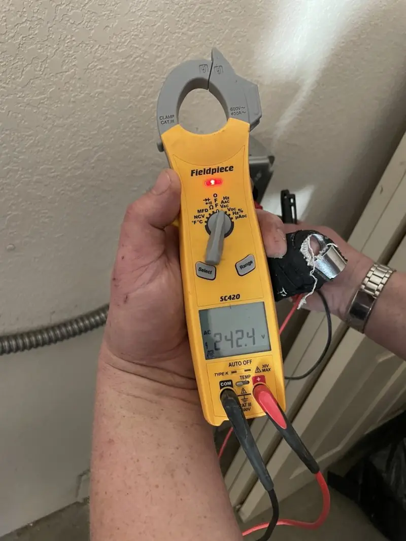 Voltage testing with clamp meter during Recessed Lighting Installation in Minot AFB